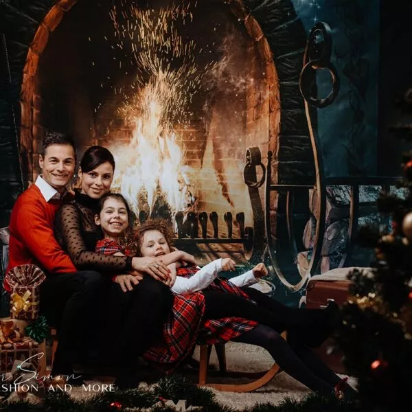 Karácsonyi fotózás stúdióban, család a kandalló előtt.